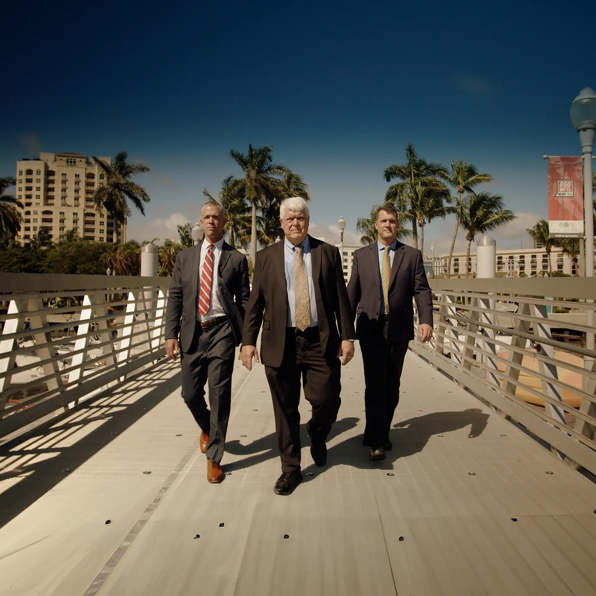 Three Lawyers in their suits walking down aboard walk
