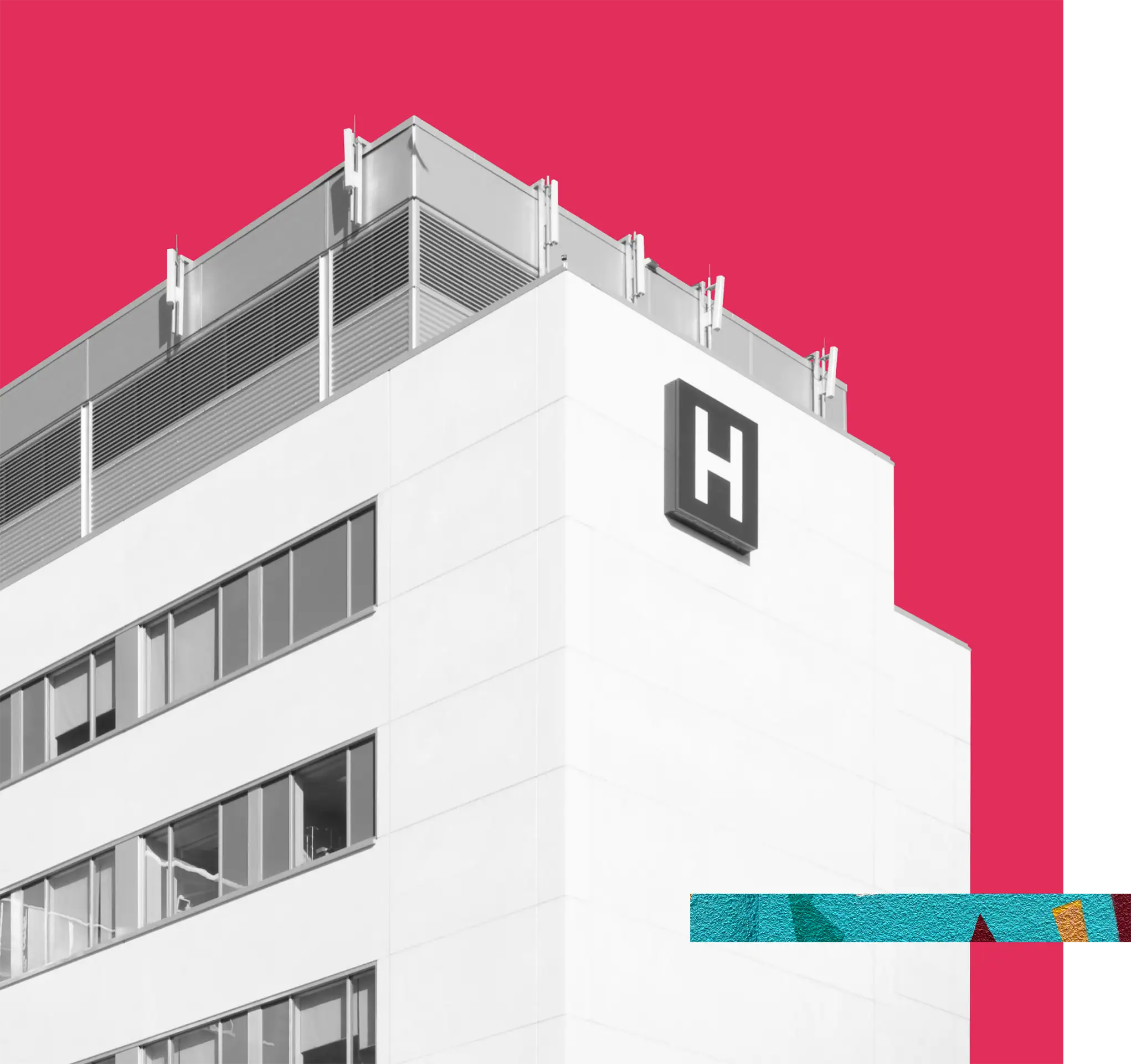 Hospital building with a large "H" sign on the white facade.