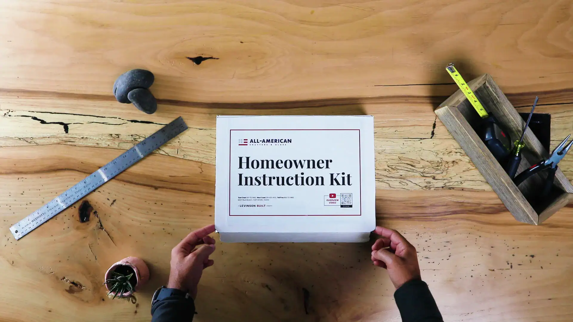 picture of someone about to open a box on a workbench with the title "homeowner instruction kit