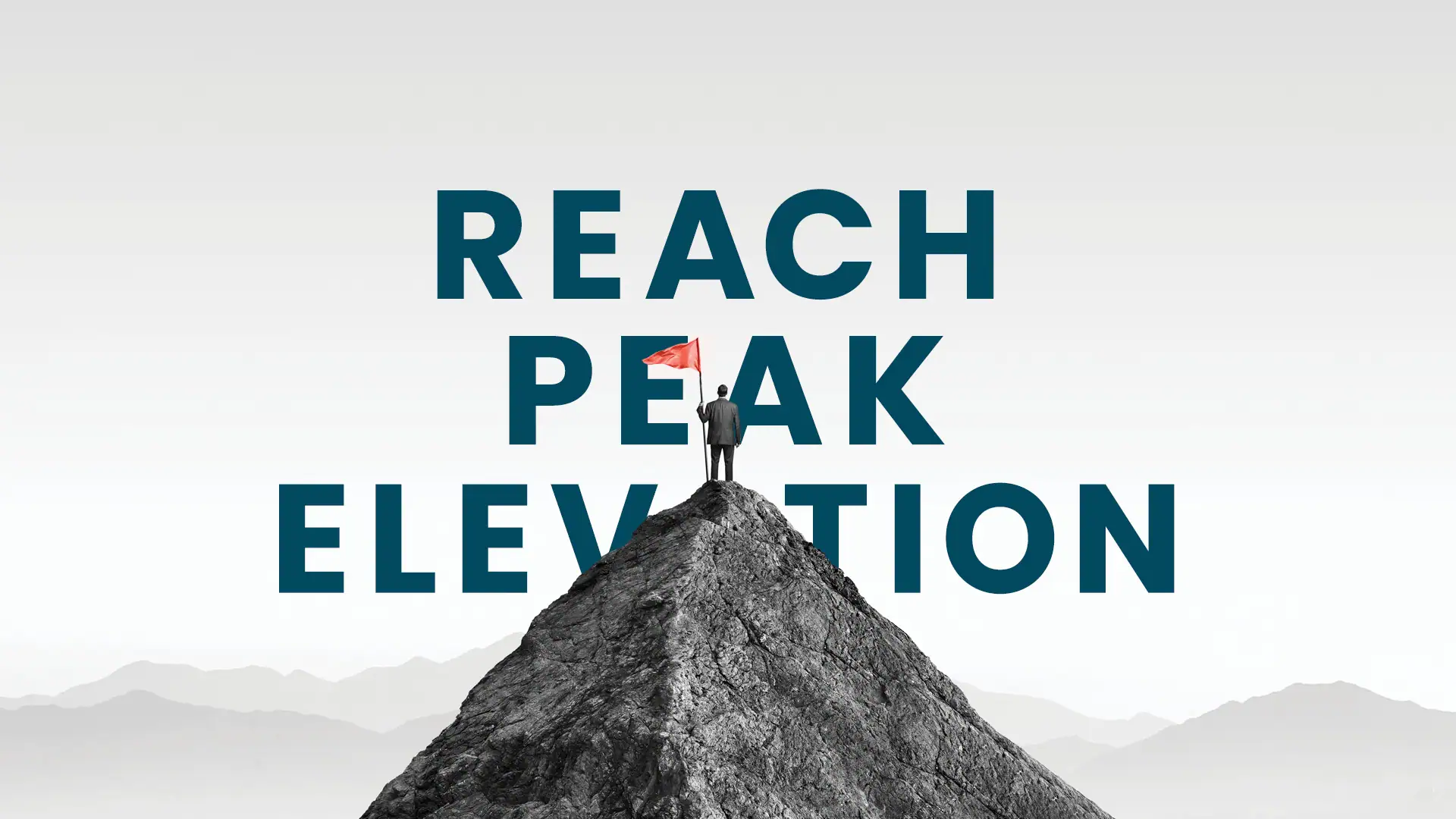 Picture of a man dressed in a suit at the top of a mountain holding a flag with the words written "reach peak elevation"