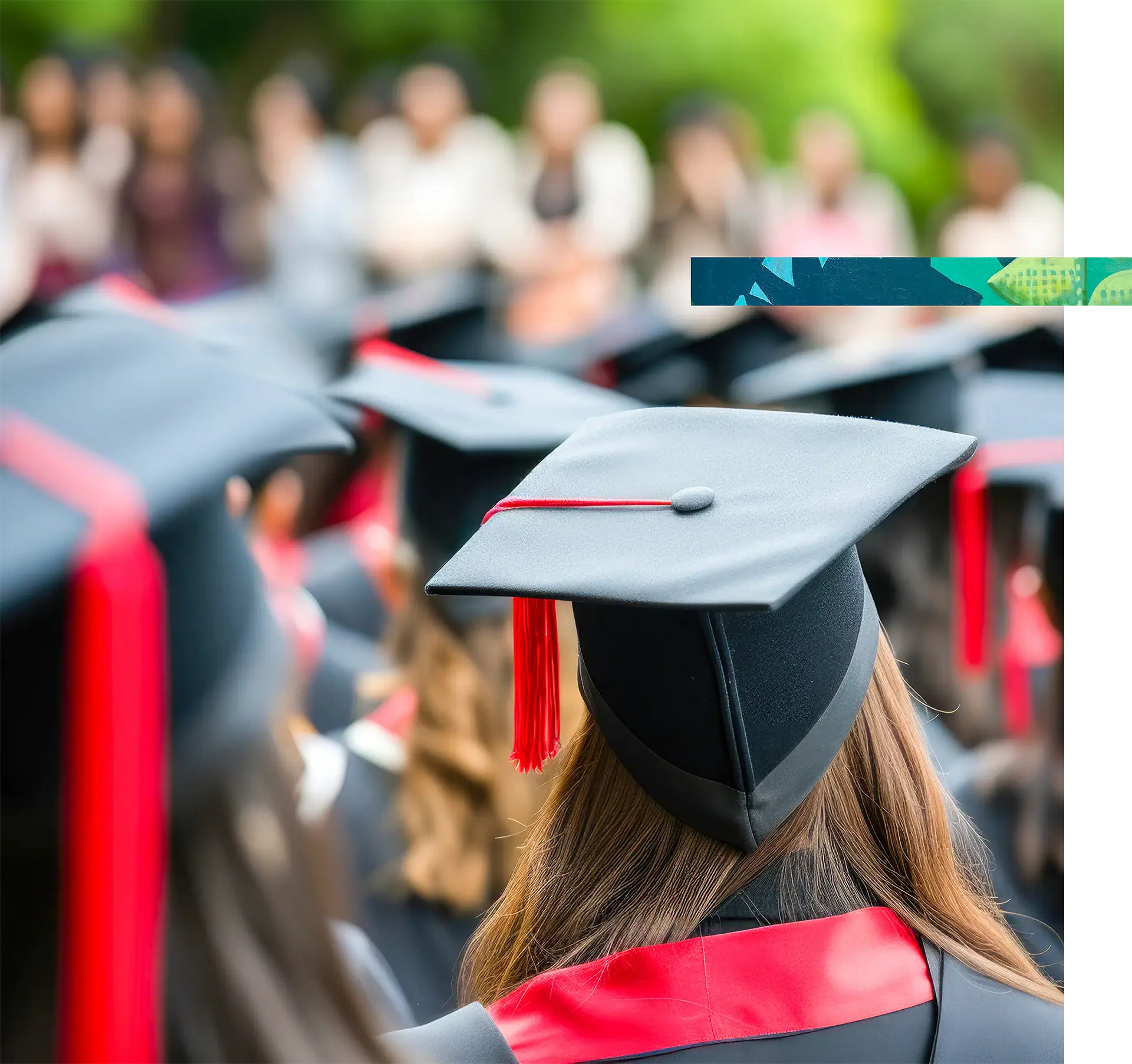 Graduates wearing caps and gowns at a graduation ceremony outdoors.