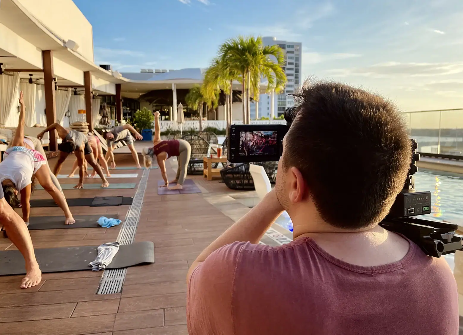 Alex filming group practicing yoga outdoors.