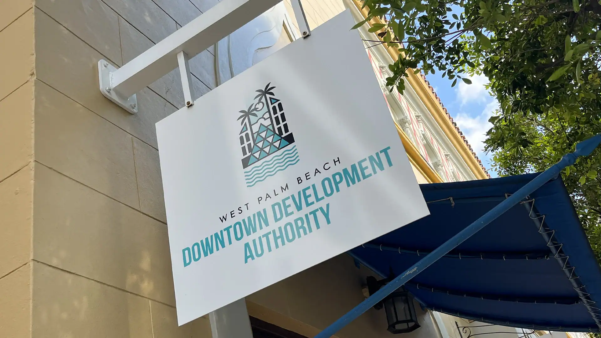 Outdoor sign for West Palm Beach Downtown Development Authority, featuring logo and tropical design.
