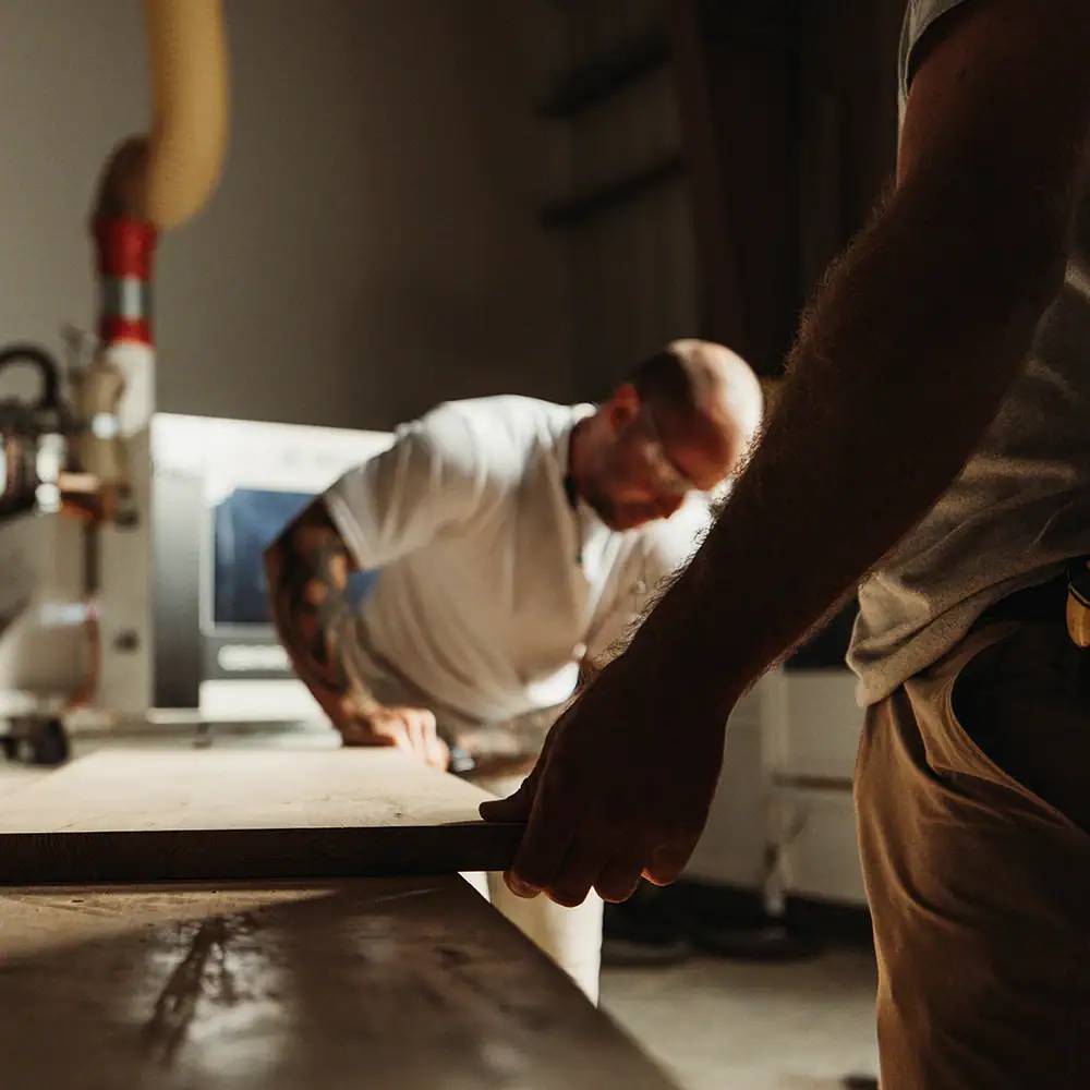 picture of two men shaping a piece of wood