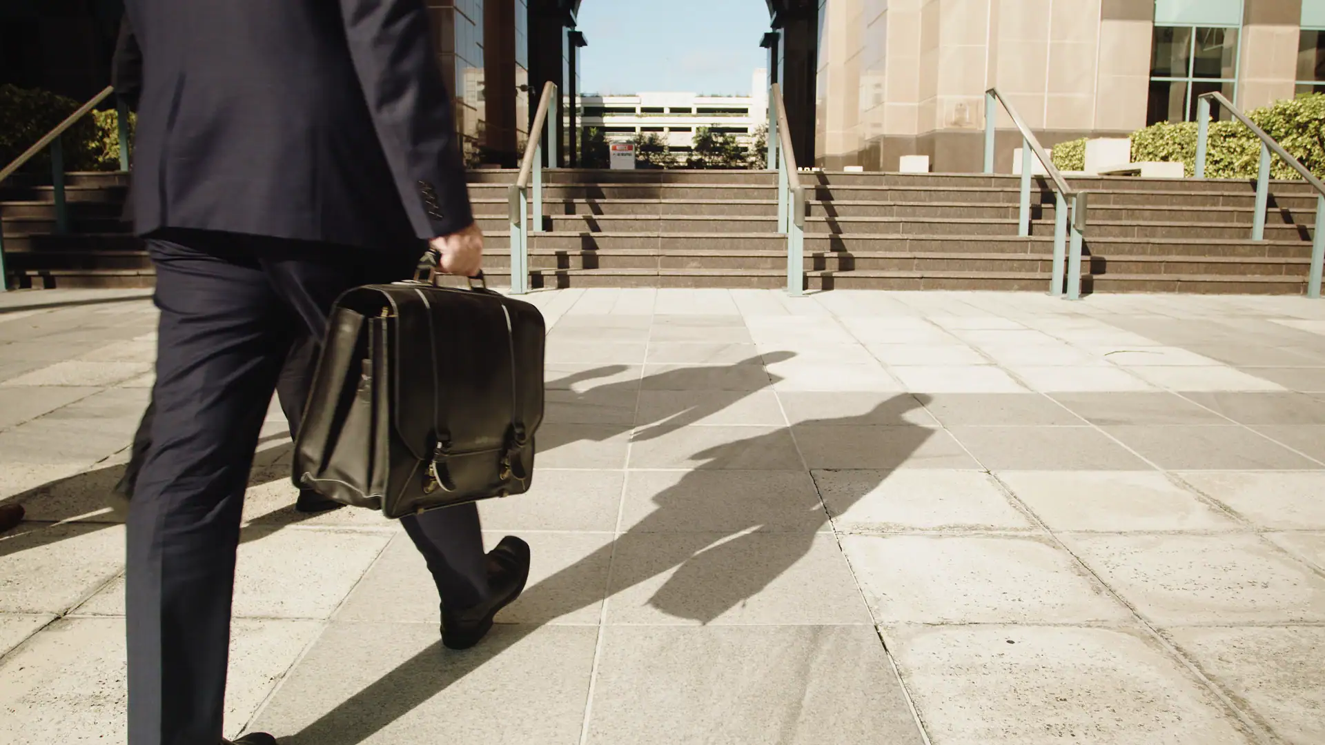 Man Carrying a briefcase about to walk up a set of stairs