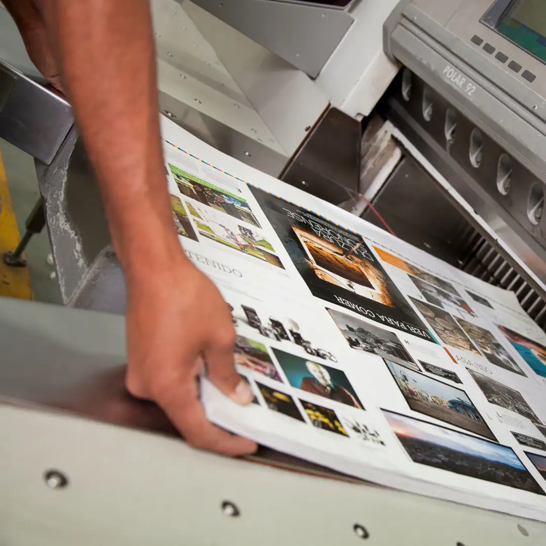 Hands pulling a collection of print images from a printer